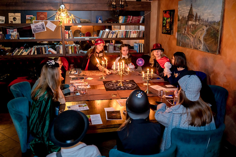 Дети разгадывают загадки в семейном квесте Хэллоуина в Astana